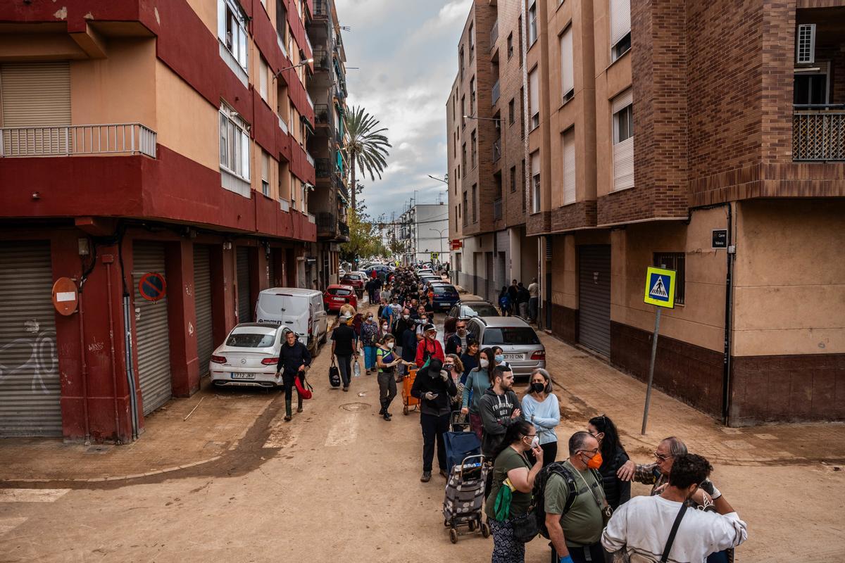 Varias personas hacen cola para recibir alimentos en una zona afectada por la DANA, a 3 de noviembre de 2024, en Benetusser, Valencia, Comunidad Valenciana (España)