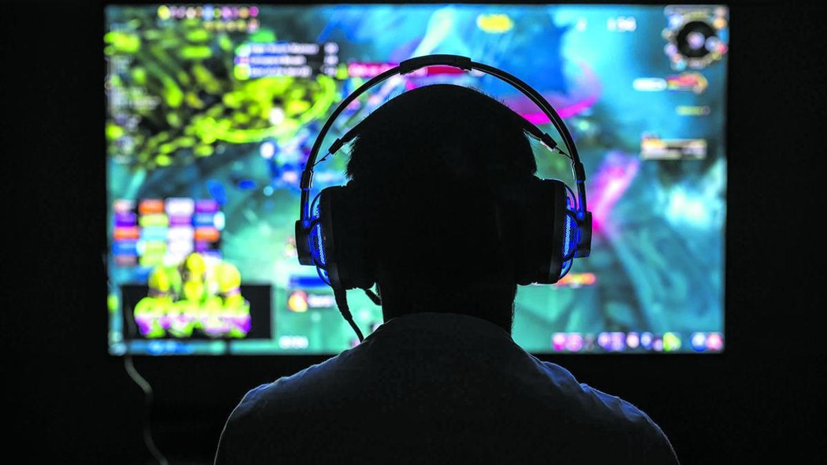 Un usuario de videojuegos juega frente a una pantalla.