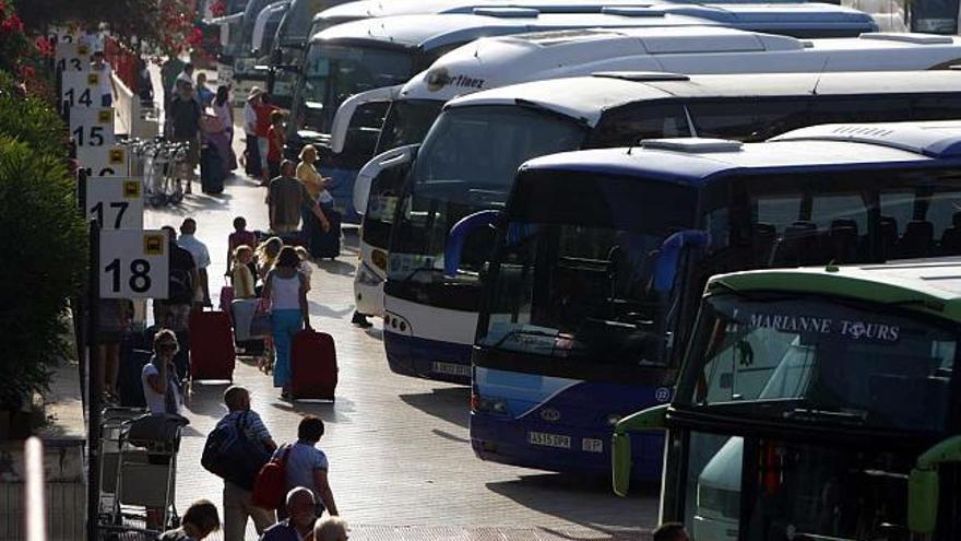 Grupos de turistas acceden a los autobuses estacionados en El Altet para desplazarse a Benidorm