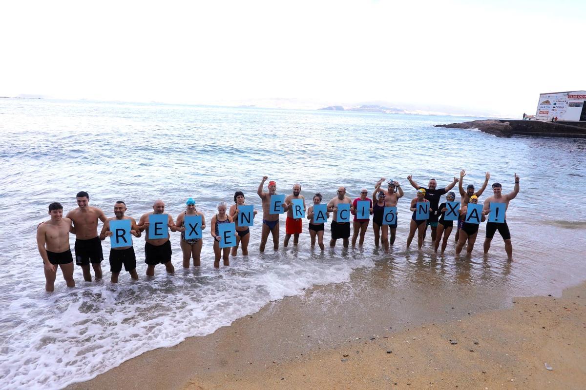 Los participantes en el baño del año pasado en Pescadoira, con cartulinas con el lema "Rexeneración Xa!".