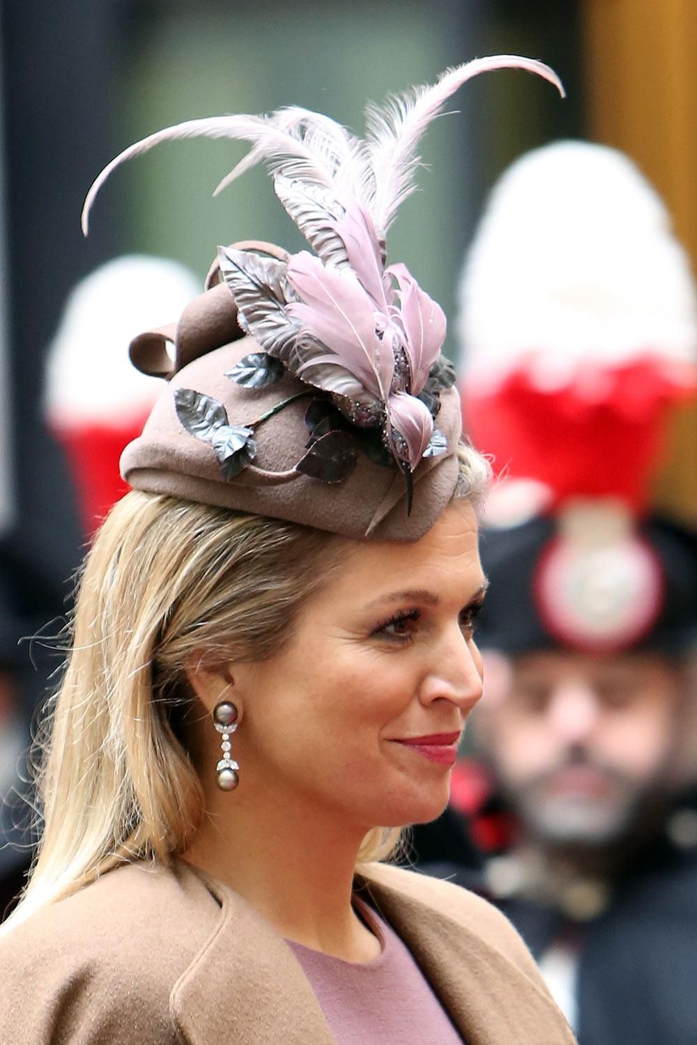 Máxima de Holanda con un tocado de plumas rosas y marrones