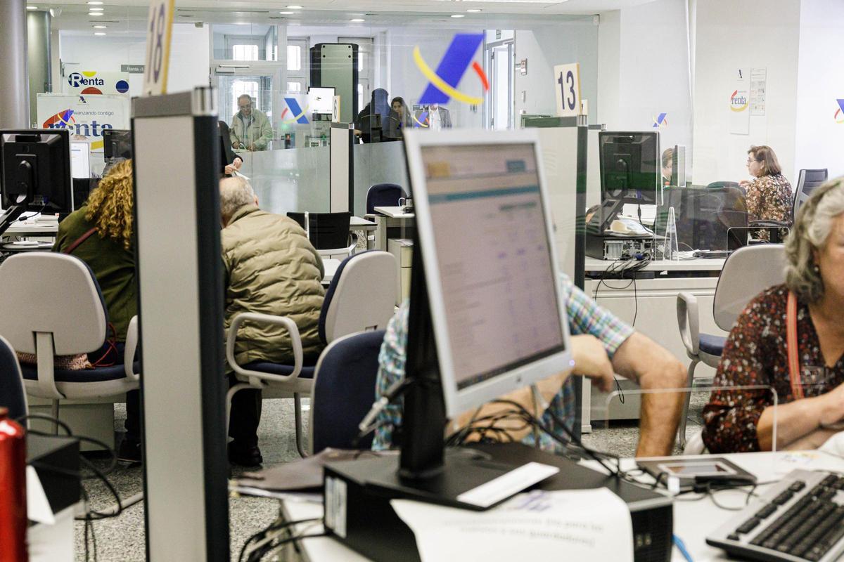 Imagen de archivo de varias personas siendo atendidas en la Agencia Tributaria para presentar la Declaración de la Renta.