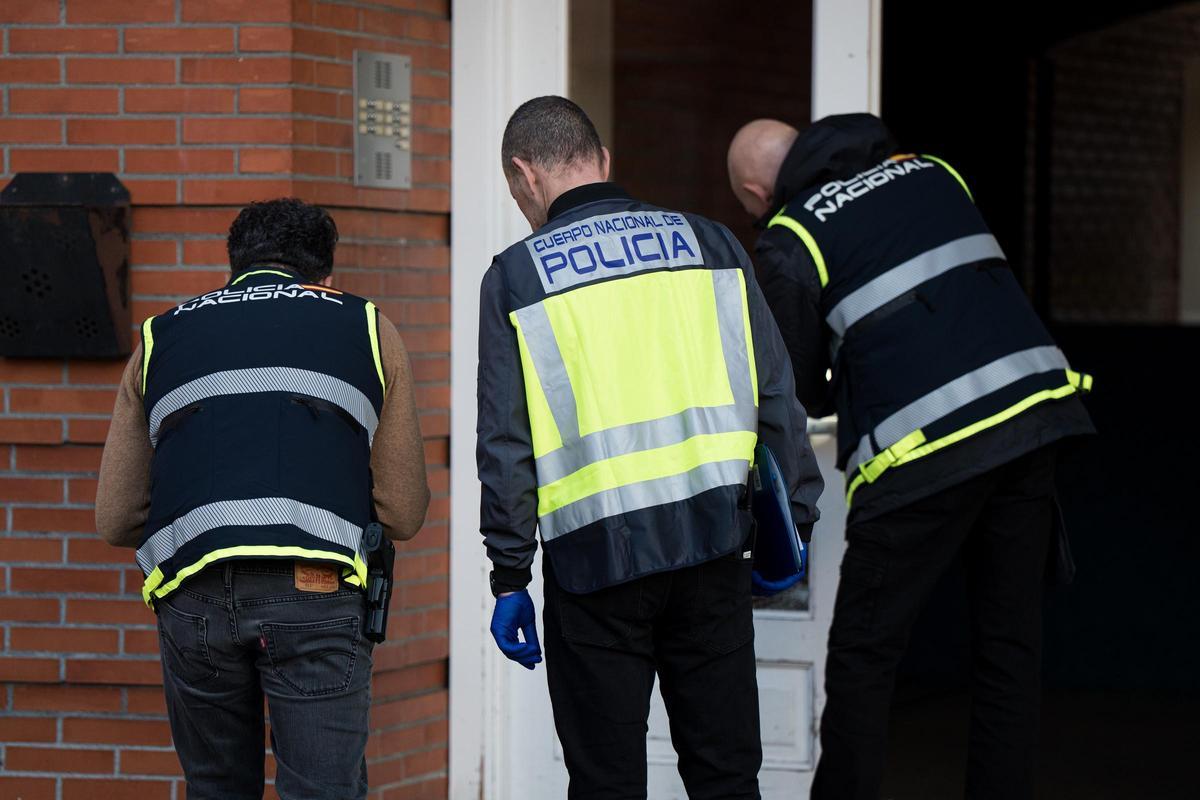 Tres policías de la Científica, en el portal donde se produjo la reyerta.