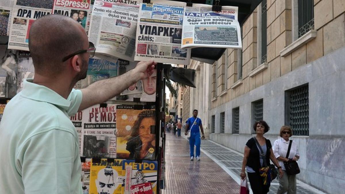 Un hombre, ojeando la prensa este miércoles en Atenas.