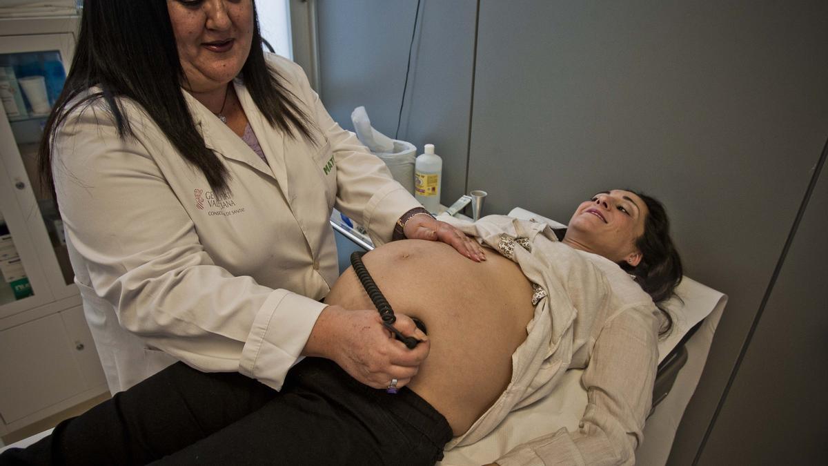 Una matrona atiende a una mujer embarazada en un centro de salud, en imagen de archivo