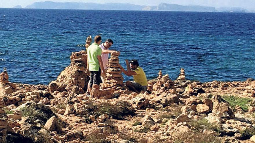 Unos turistas haciendo su montículo el pasado jueves, con Cabrera de fondo.