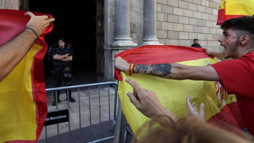 Varias personas increpan a mossos en la puerta de la Generalitat.