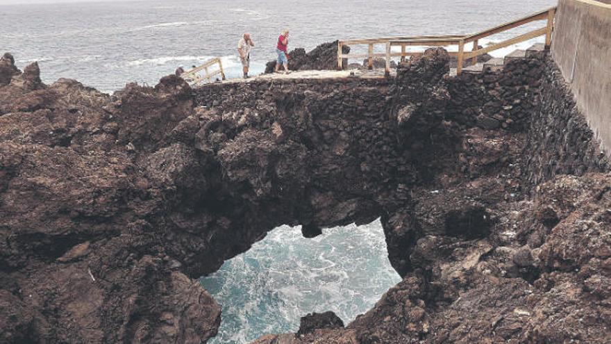 Un arco de piedra en la costa del barrio portuense de Punta Brava.