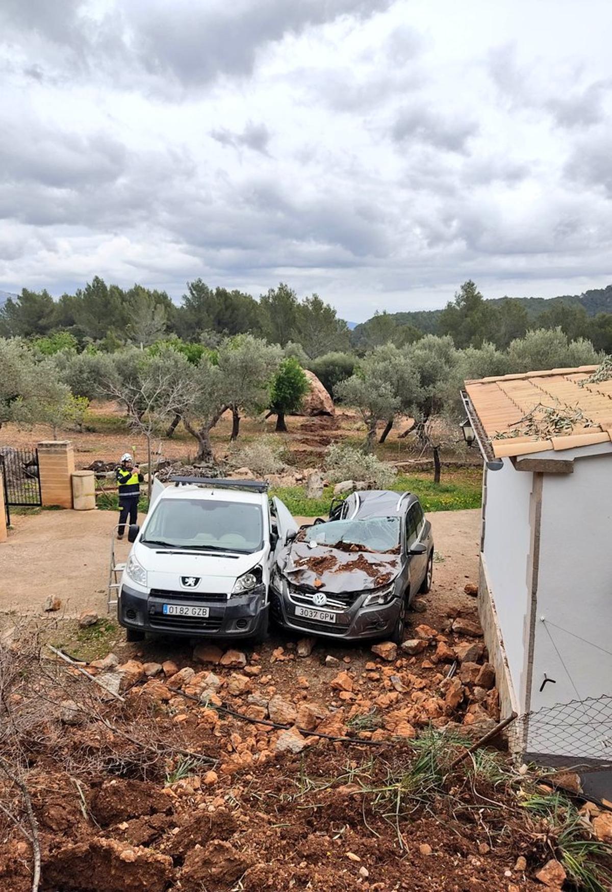 Dos vehículos aplastados por la roca que cayó.