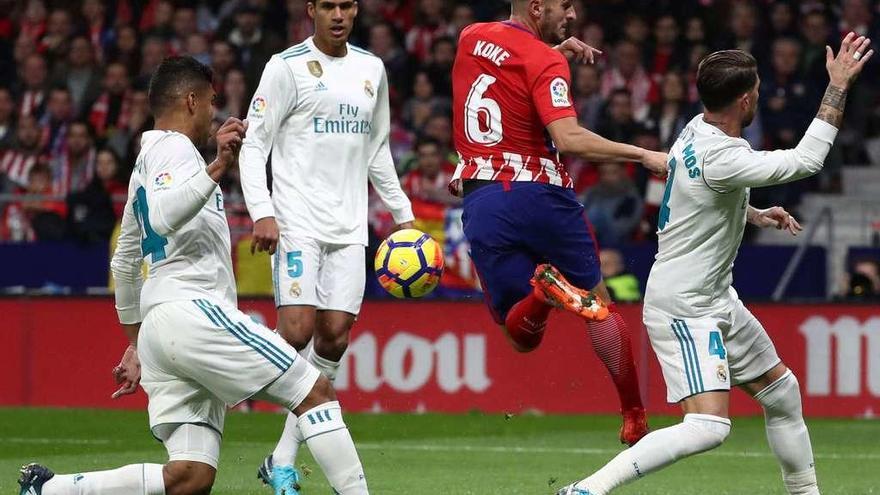 Koke falla un remate en el área del Real Madrid, ante Sergio Ramos, Varane y Casemiro. // Juan Medina