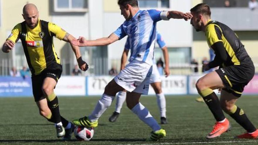 Chechu Flores y Adrián Jiménez intentan frenar la acción de un jugador del Baleares.