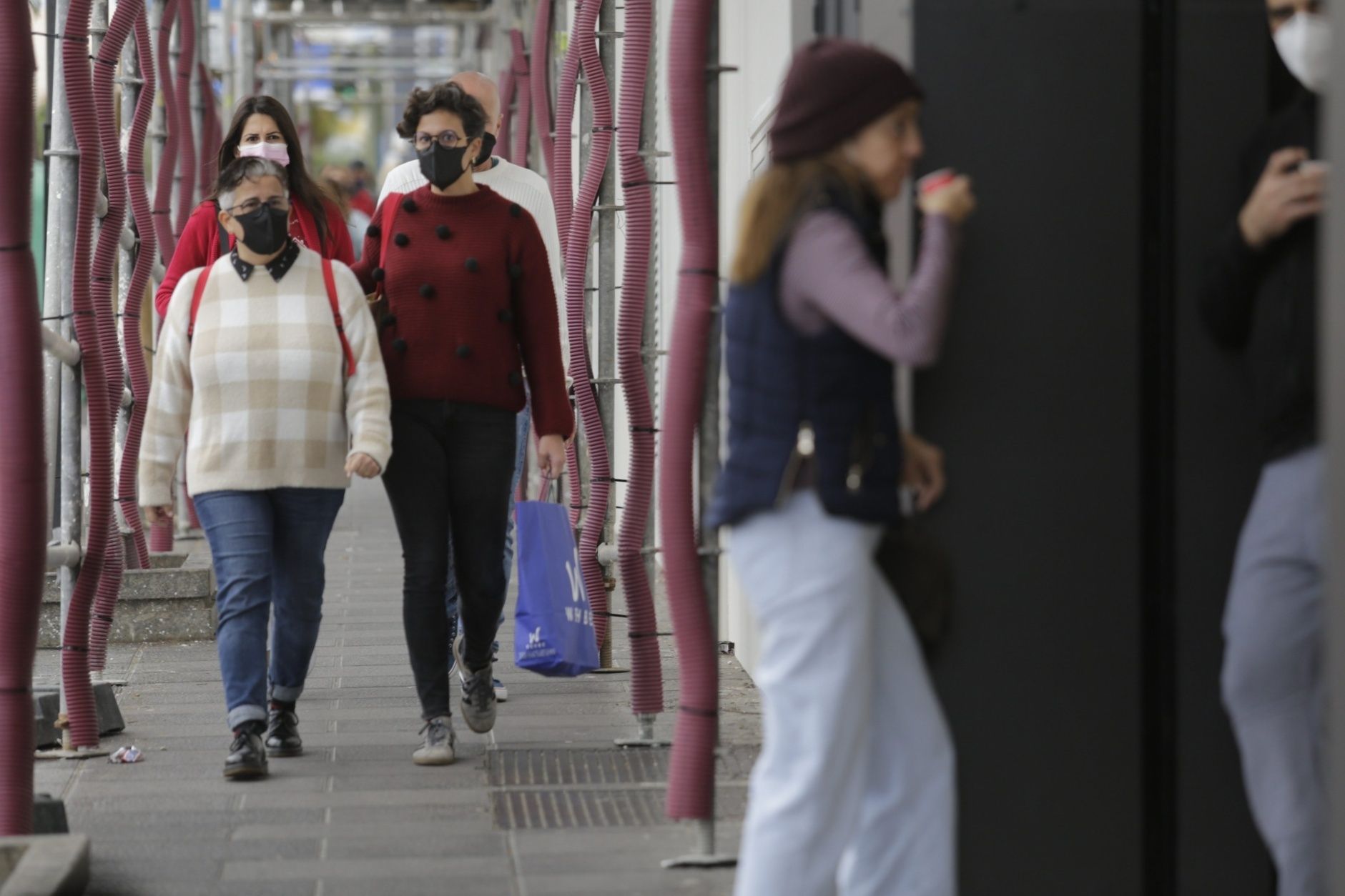 Gente paseando con mascarillas este domingo.