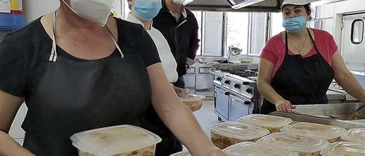 Voluntarios del comedor social preparan los macarrones en su primer dÃ­a de servicio.