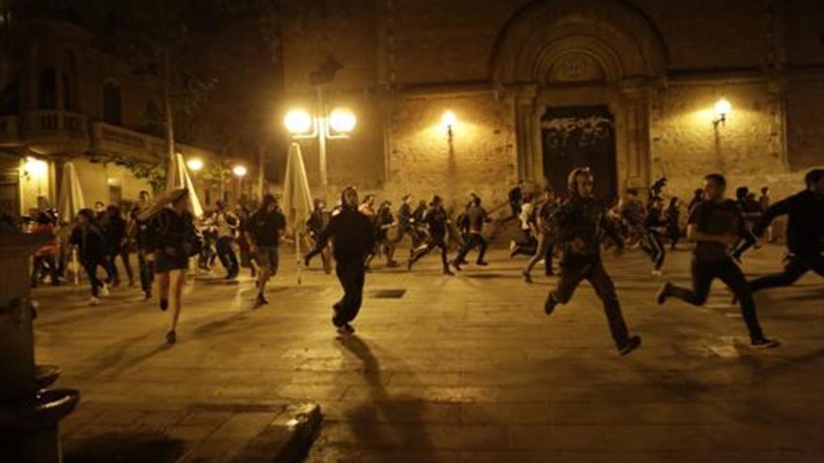 Un momento de una de las carreras de los manifestantes, anoche, en Gràcia.