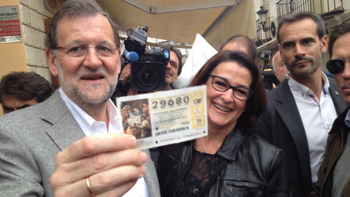 Mariano Rajoy recibe un décimo de lotería durante su recorrido por Estepona (Málaga).