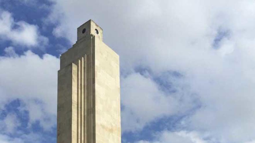 El obelisco de sa Feixina con dos personas portando banderas preconstitucionales.