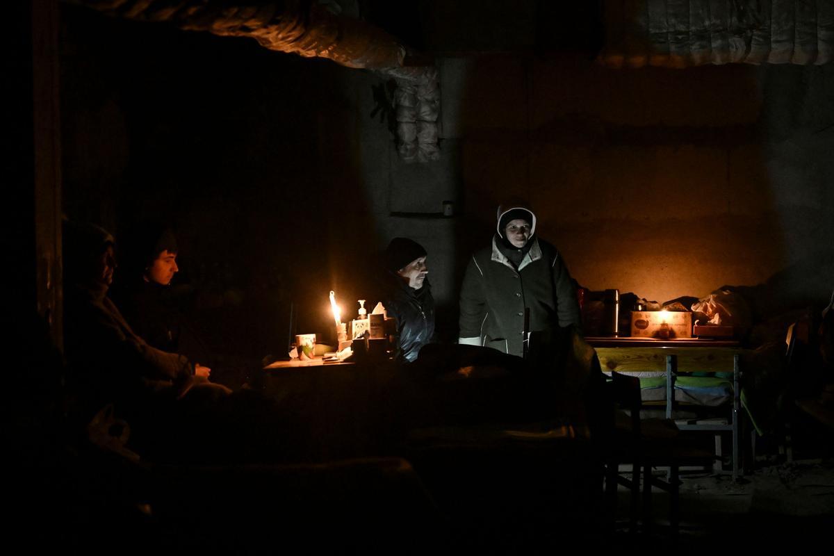 Las personas se refugian en el sótano de una escuela donde han estado viviendo durante un mes, a lo largo de un distrito de primera línea de Kharkiv el 27 de marzo de 2022. - Un barrio de clase trabajadora de bloques de gran altura en las afueras del noreste de la segunda ciudad más grande de Ucrania, a tiro de piedra de los primeros campos de tierra negra arada en el campo. Las tropas rusas, que están acampadas a pocos kilómetros, saquean el lugar todos los días, con toda su armada. El Distrito 4 no es más que un pueblo fantasma, un campo de batalla devastado.