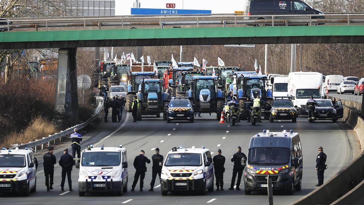 La Policía vigila a los tractores en la autopista A-15, al norte de París, este lunes.