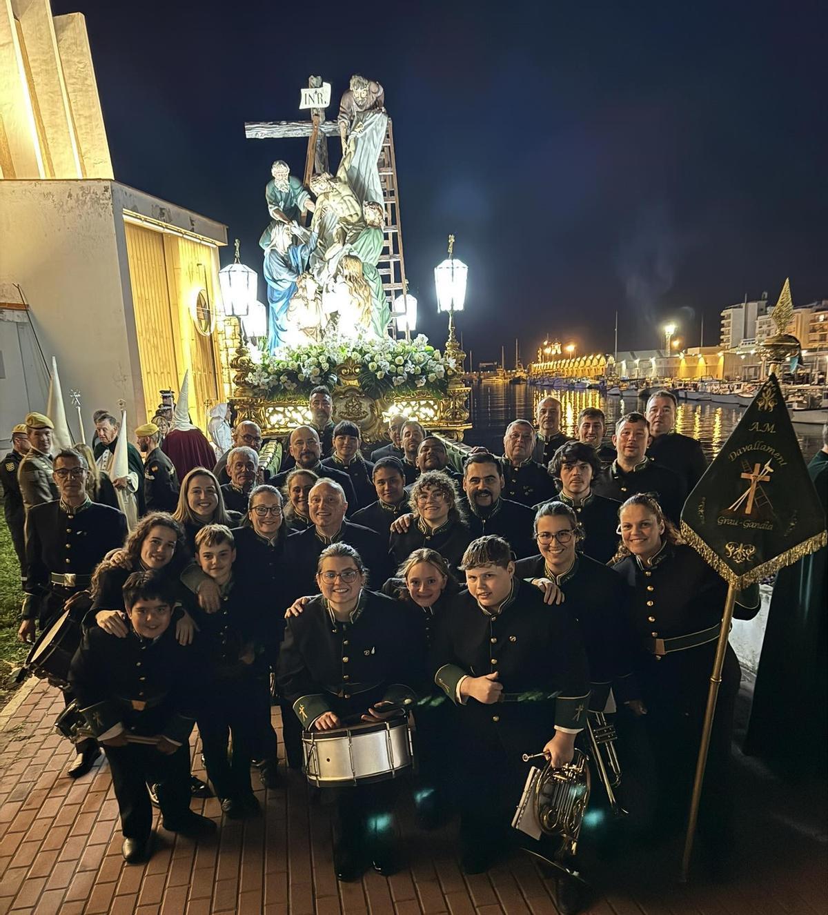 Músicos delante de la imagen en el puerto de Gandia.