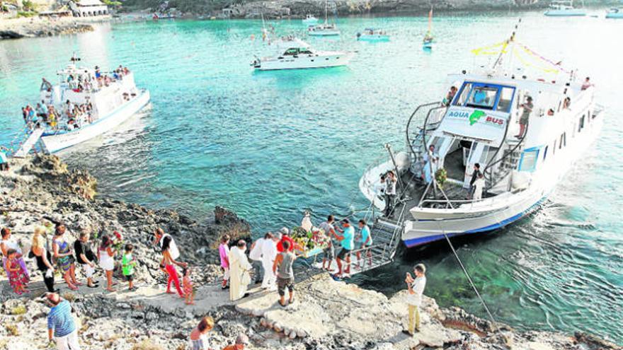 Los porteadores de la imagen la embarcan en uno de los extremos de la bahía.