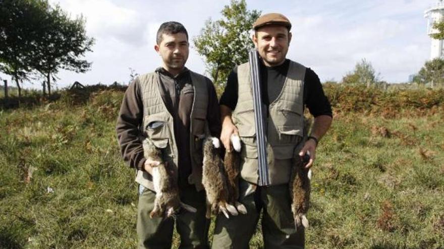 Dos cazadores con conejos, ayer, en el coto de Moaña-Marín.  // Carmen Giménez