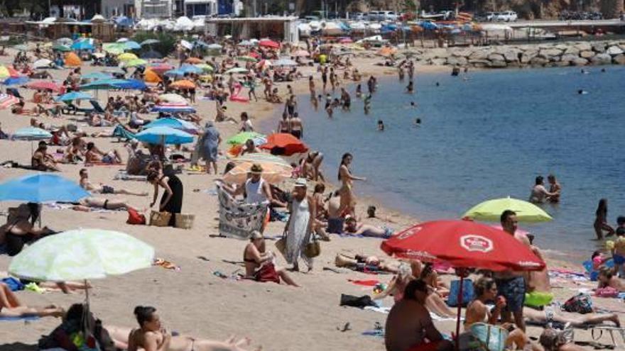 Molts banyistes es refugiaven de la calor ahir a la platja de Sant Feliu de Guíxols.