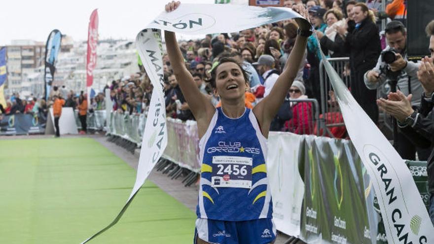 Esther Ramos levanta la cinta de meta de la prueba de los 21 kilómetros de la Gran Canaria Maratón.