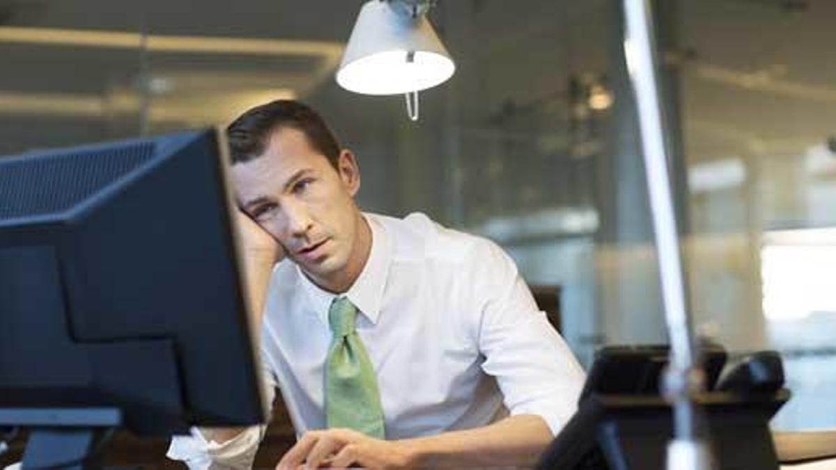 Un trabajador, ante su ordenador en la oficina.
