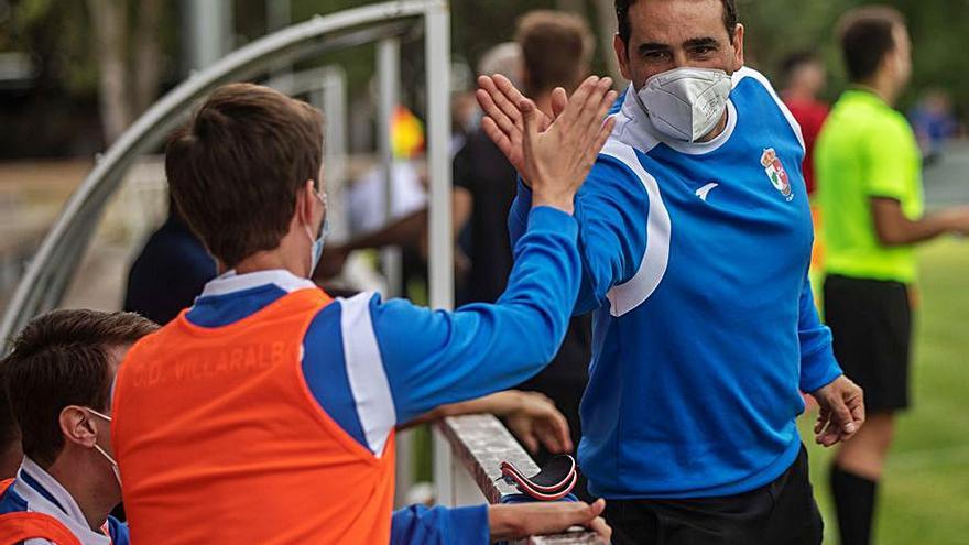 Miguel Losada choca con uno de sus jugadores.