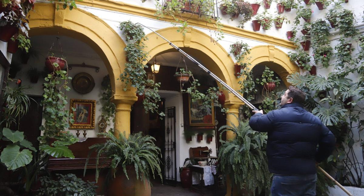 Cuidadora del patio Jesús del Calvario 16 manteniendo las flores que permanecen durante todo el año.