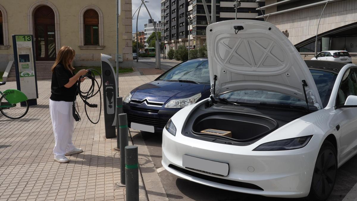 Una mujer se dispone a cargar un coche eléctrico en un punto público de Castelló.