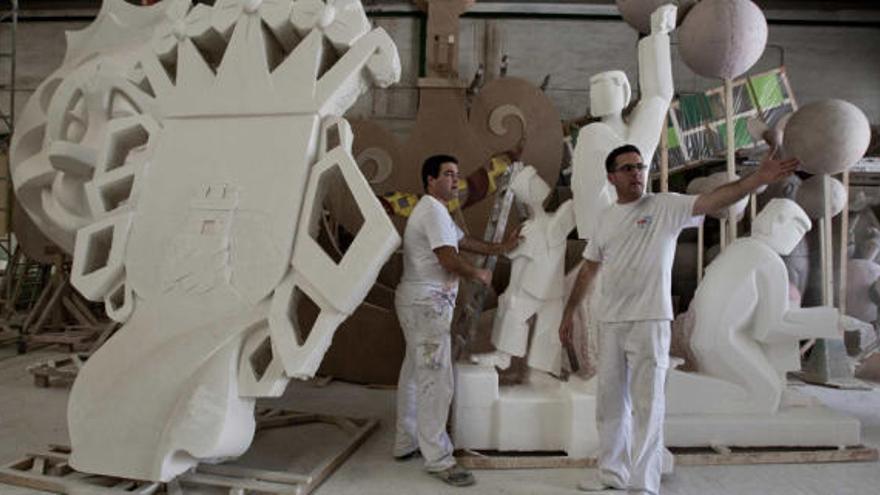 Dos de los hermanos Gómez Fonseca con algunas de las piezas de la Hoguera Oficial en su taller, en el que ya empiezan a acumular escenas embaladas a la espera de la plantà.