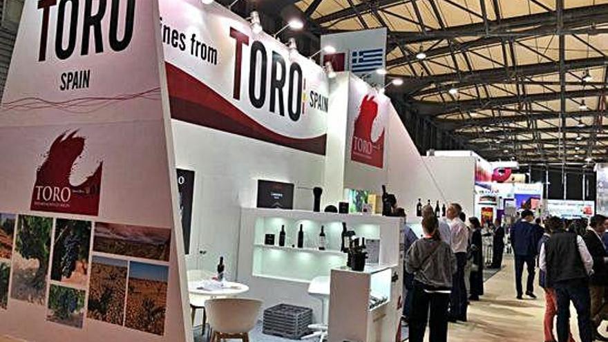 Visitantes recorren el stand promocional del Consejo Regulador de Toro en una feria internacional.