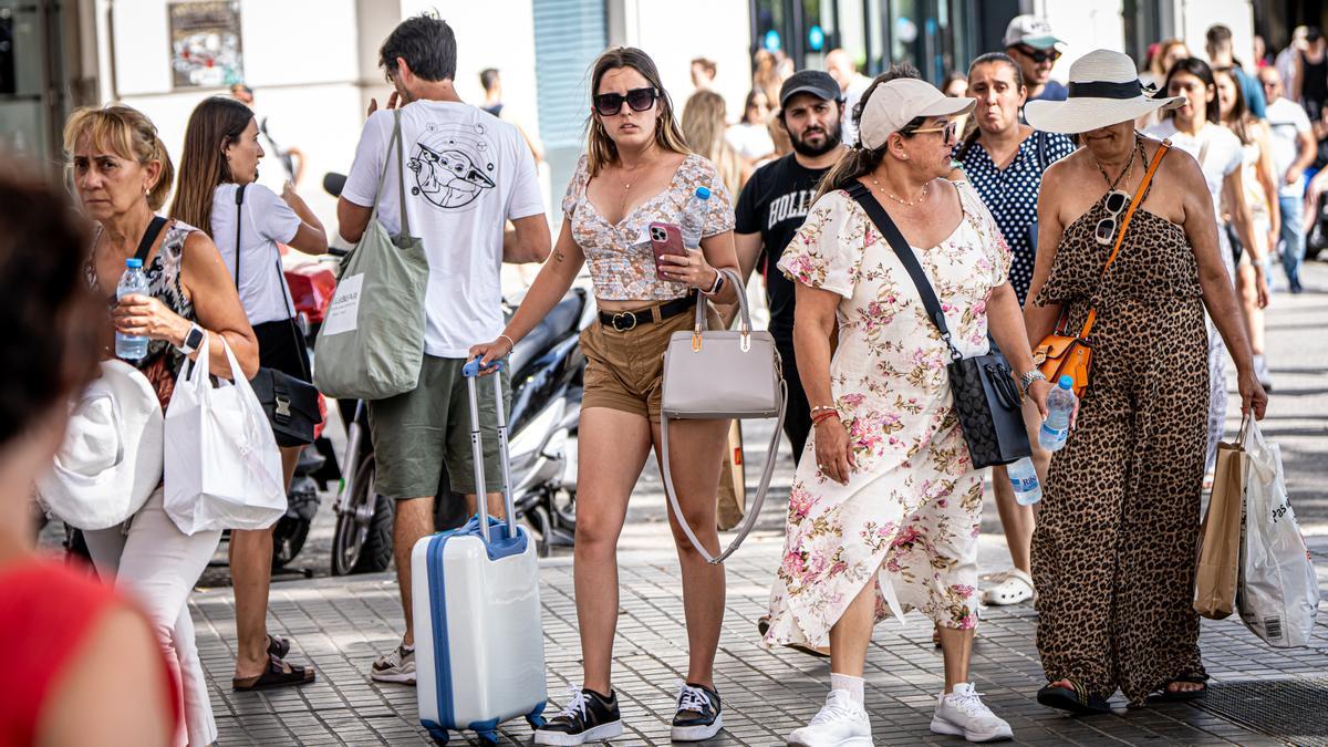 Personas pasean por las calles de Barcelona, a pesar del calor