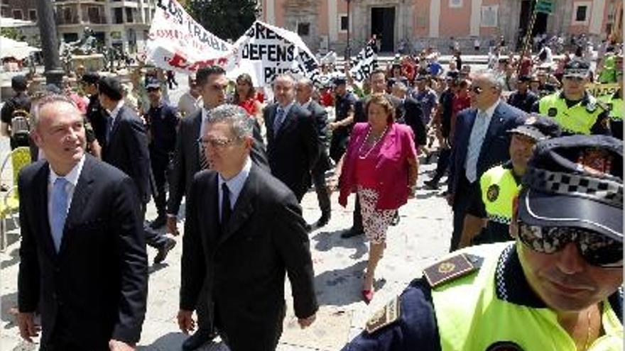 La comitiva de autoridades atraviesa la plaza de la Virgen en medio de las protestas.