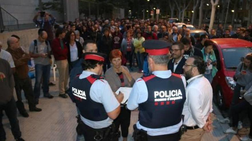 Dos agents dels Mossos amb votants la matinada de l&#039;1 d&#039;octubre.