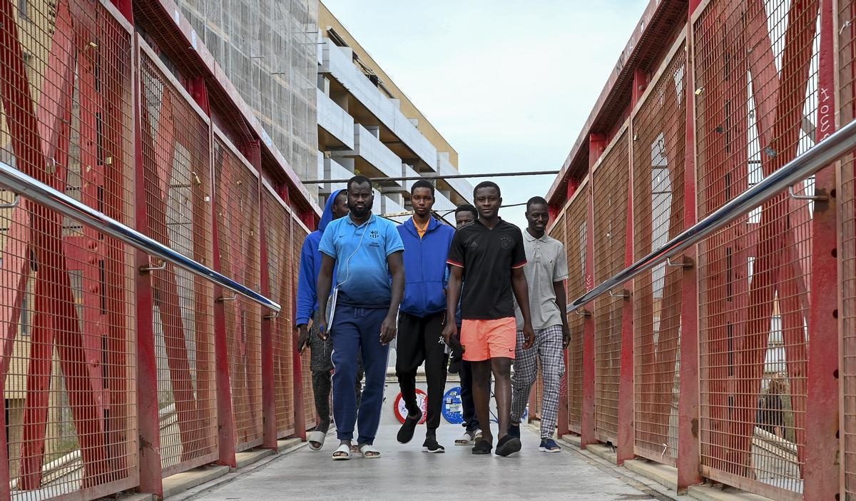 Los seis jovenes malienses cruzan las vías del tren en Badalona.