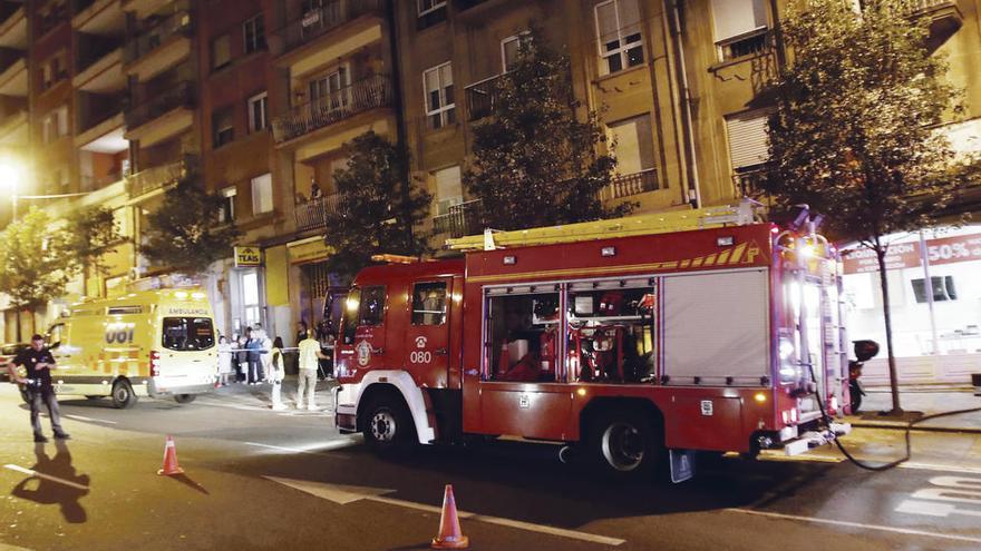 Arriba, bomberos y ambulancia, en la zona del incendio. A la izquierda, las llamas. // R. Grobas/FdV