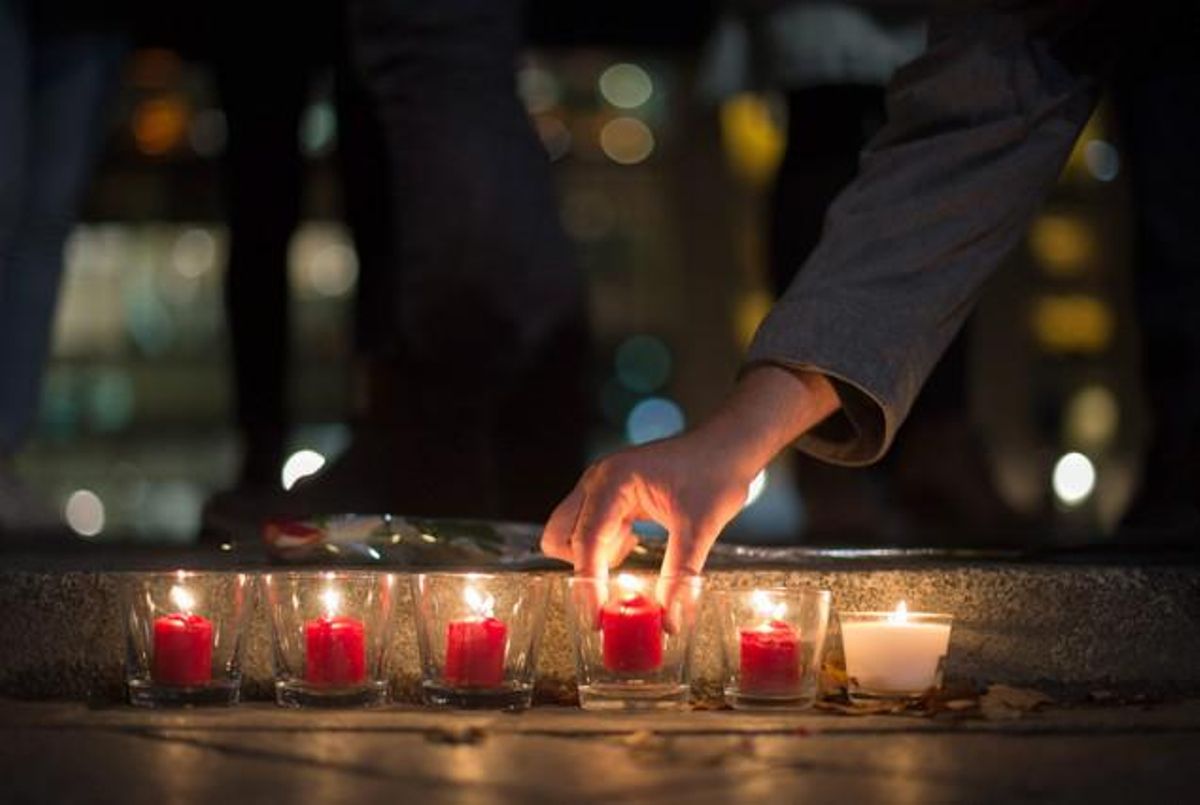 La gent encén espelmes en homenatge a les víctimes dels atemptats de París, davant de l’Ambaixada de França a Berlín.