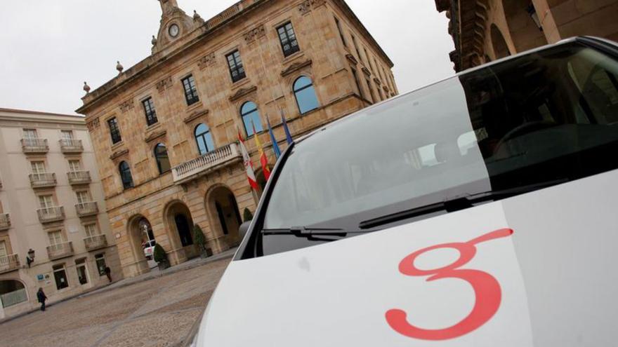 Un vehículo con el logo de Gijón ante el Ayuntamiento. | JUAN PLAZA