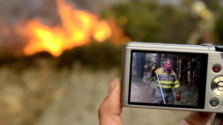 Un compañero de Higinio Vivas López, el brigadista fallecido en la extinción de un incendio forestal muestra en la pantalla de una cámara la imagen del fallecido instantes antes del suceso.