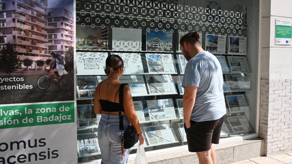 Dos jóvenes observando el escaparate de una inmboliaria en Badajoz, ayer por la tarde