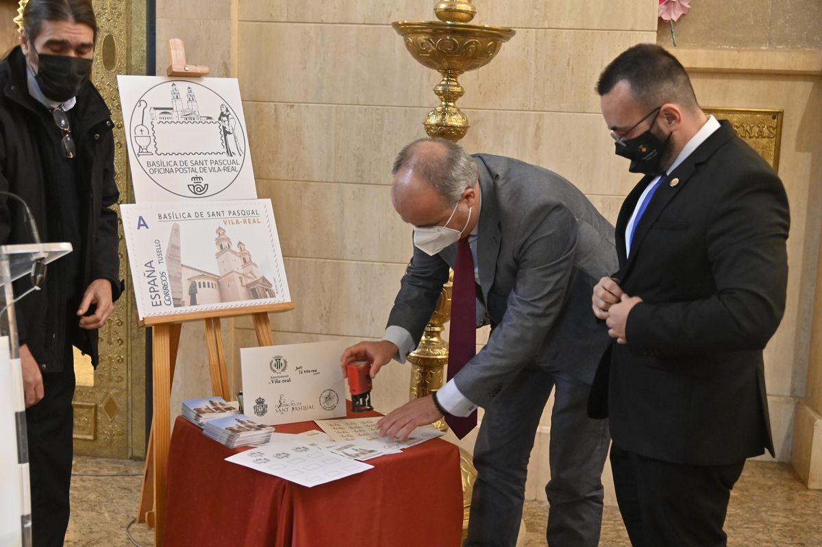 El alcalde Benlloch y el director regional de Correos, Francisco Briceño, prueban el matasellos sobre estampillas conmemorativas de Sant Pasqual.