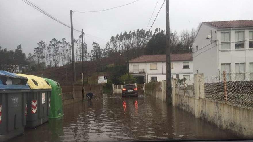 Vial junto al colegio de Espiñeira, en Aldán, anegado por la tromba de agua por la tarde. // Santos Á.