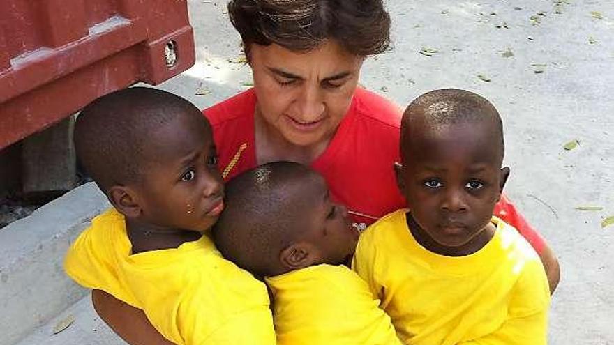 Pilar Méndez, junto a tres niños haitianos del centro que visitó.