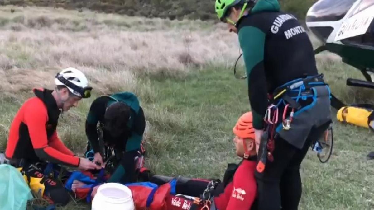 Tres especialistas de la Guardia Civil atienden al barranquista francés que sufrió una caída.