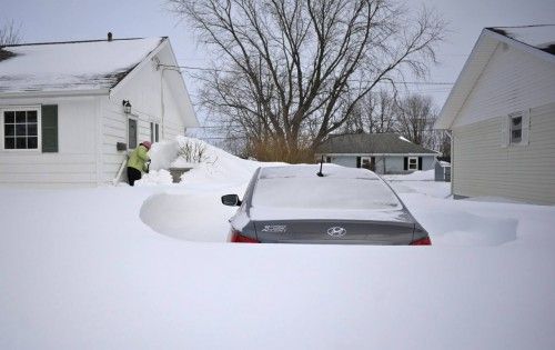 Una mujer aparta la nieve alrededor de un coche en Charlottetown, Canadá