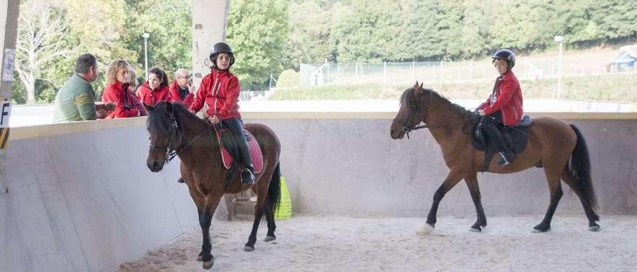 Una amazona y un jinete ayer en las instalaciones de Mouriscade y peinado de crines a un caballo. // Fotos: Bernabé/Ana Agra