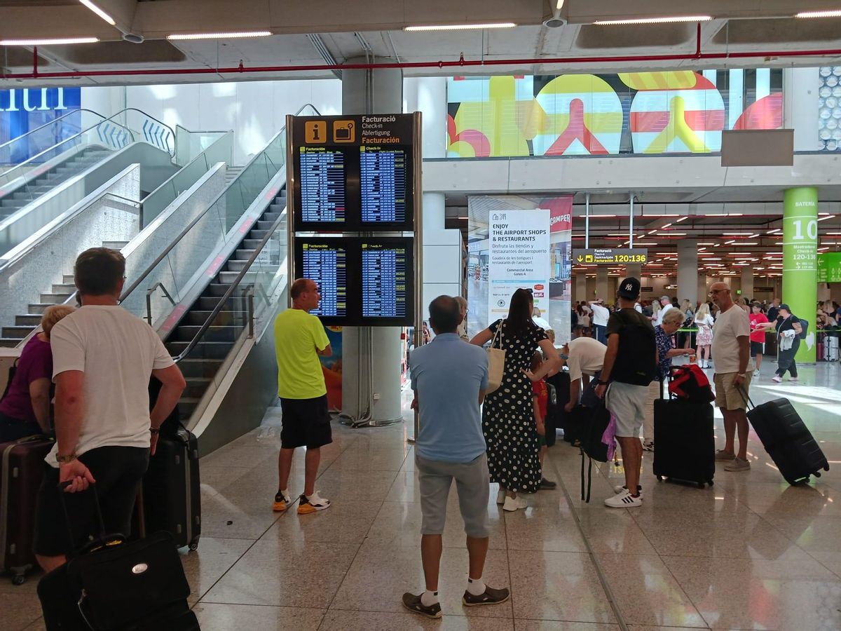 Pasajeros observando el estado de sus vuelos esta mañana en el aeropuerto de Palma