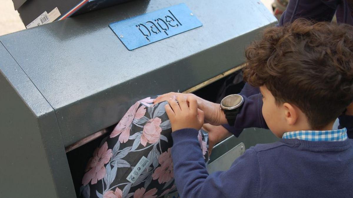 Un menor recicla residuos de cartón y papel en la Costa del Sol.